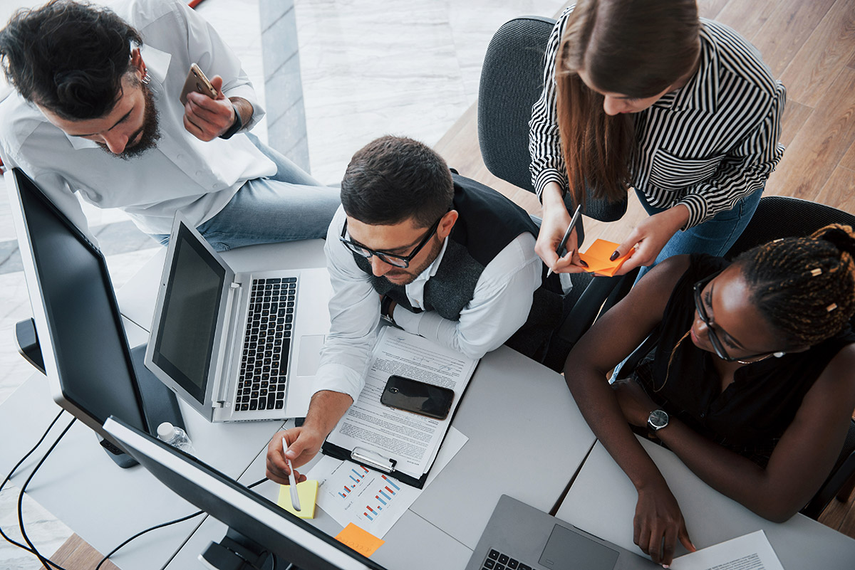 Team around desk planning for cyber risk for businesses